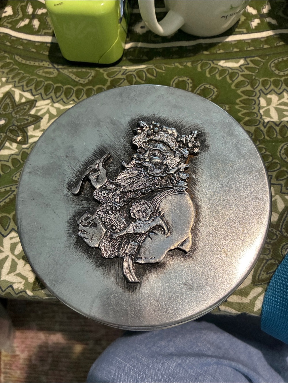 1970s Vintage Pewter Tin, 6” round. Raised Santa Clause w/Pipe, Doll &Presents.